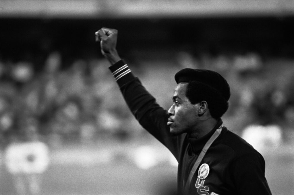Un athlète américain lève le poing en symbole de la lutte contre la discrimination raciale aux États-Unis. Mexico, Mexique. L'athlète Lee Evans, vainqueur du 400m en 43,86 sec. 1968