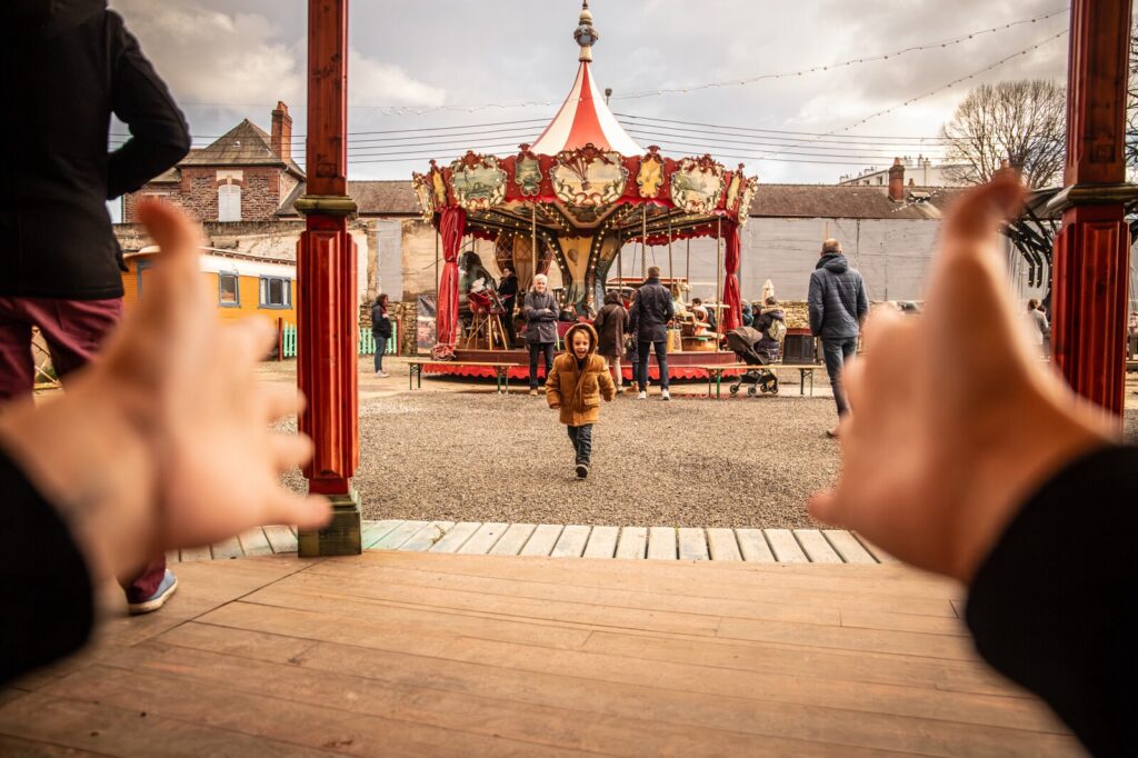 Enfant à côté d'un manège du Grand Huit à Rennes