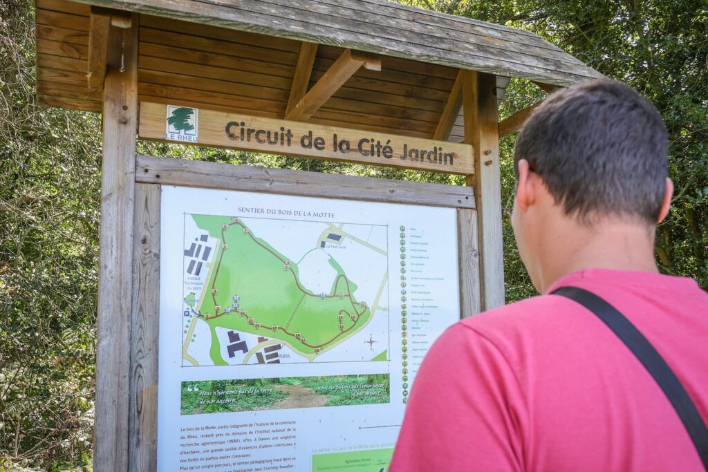 Promeneur devant le panneau d'information du bois de La Motte au Rheu.