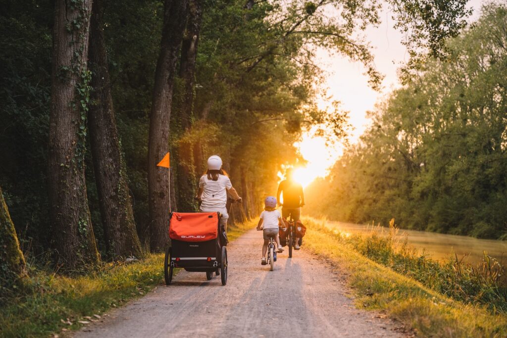 Famille de cyclotouristes sur le chemin de halage en Bretagne au coucher du soleil