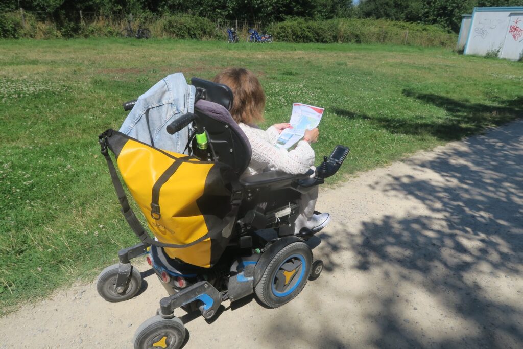 Personne en fauteuil roulant se promenant sur une balade à roulette.