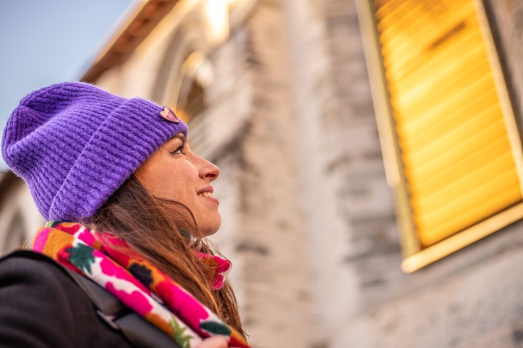 Femme souriante avec un bonnet devant l'oeuvre de Laurent Grasso au Couvent des Jacobins