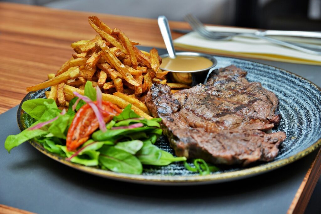 Plat de viande accompagné de frites et de salades dans le restaurant le Grill à Rennes