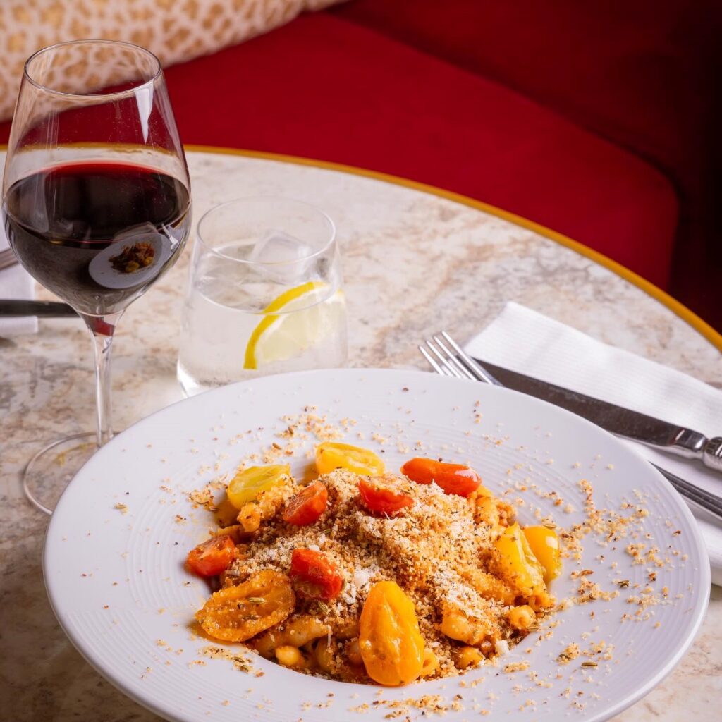 Plat dans une assiette creuse et verre de vin rouge