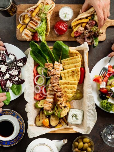 Vue de haut d'une table de restaurant avec des spécialités grecques que se partagent deux convives.